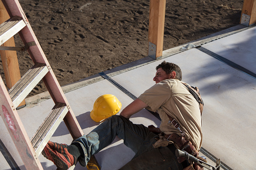 Carpenter building a home at construction site. Falling off ladder. Injured leg.